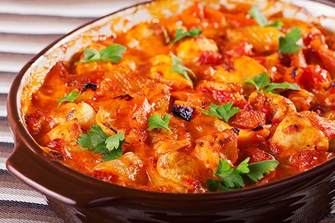 Casserole with chicken, potatos and tomatos in a baking dish, ready-to-eat