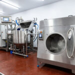 Industrial stainless steel food processing equipment used in sustainable food production within a hygienic manufacturing facility.