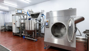 Industrial stainless steel food processing equipment used in sustainable food production within a hygienic manufacturing facility.