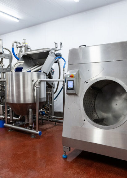 Industrial stainless steel food processing equipment used in sustainable food production within a hygienic manufacturing facility.