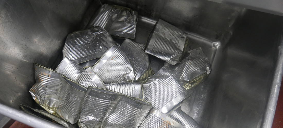 An industrial can crusher that has been used to crush food cans in a food factory.