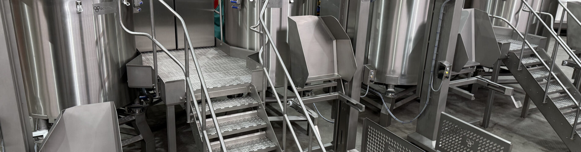 Large stainless steel industrial electric kettle used in commercial food processing and high-capacity industrial cooking operations.