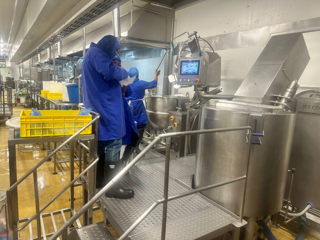 Food Manufacturing Training in a production facility with operators working on industrial food processing equipment.
