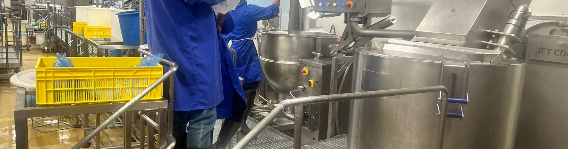 Food Manufacturing Training in a production facility with operators working on industrial food processing equipment.